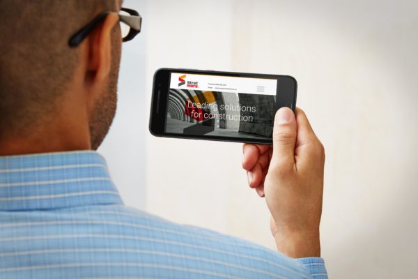 Man holding a mobile phone showing a mobile optimised website by Wonderlab.