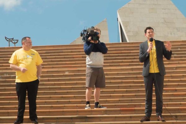 Men wearing branded yellow t-shirts at a public engagement event designed by Wonderlab